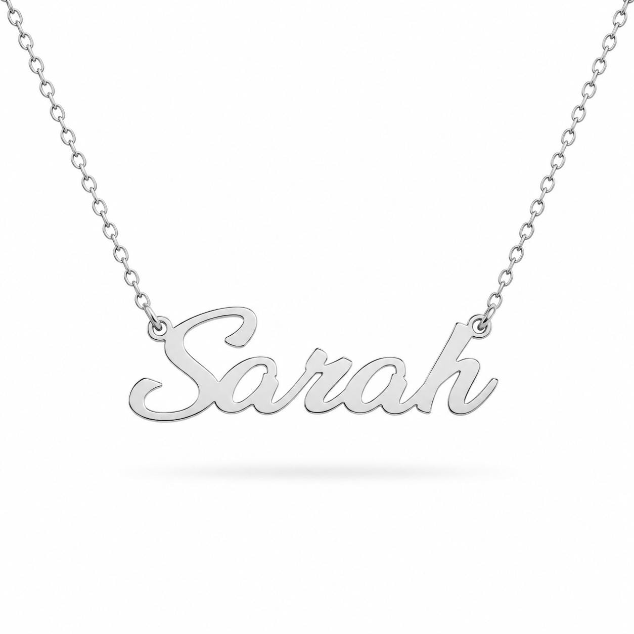A silver necklace with the name "Sara" engraved on it.