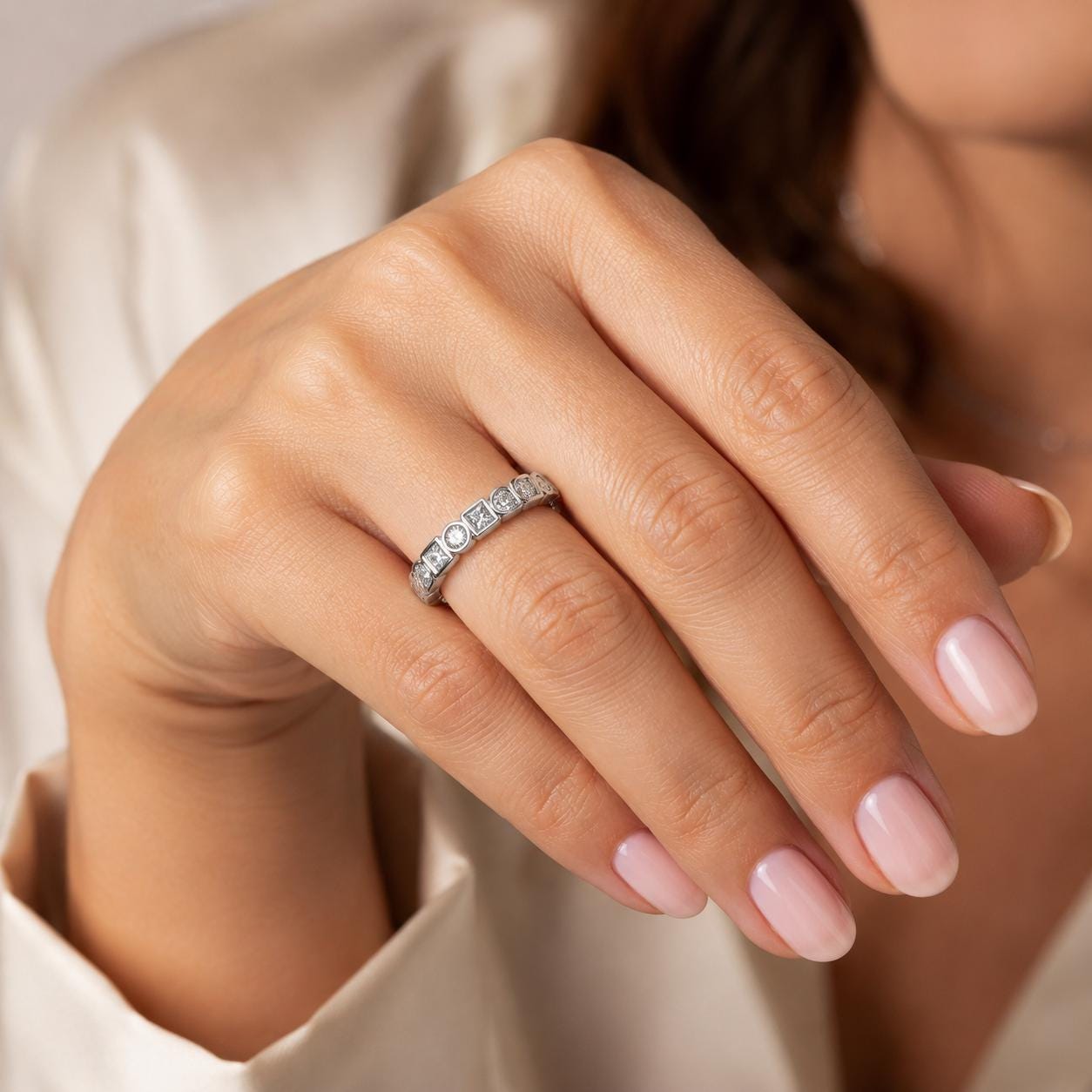 A close-up of a person's hand wearing a diamond ring on the ring finger.