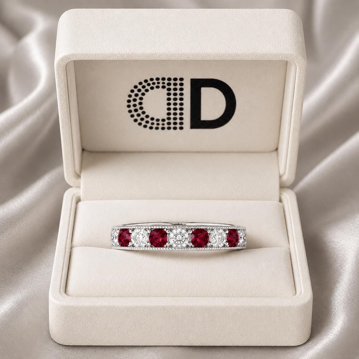 A white jewelry box containing a ring with a band of red gemstones and a large central diamond.