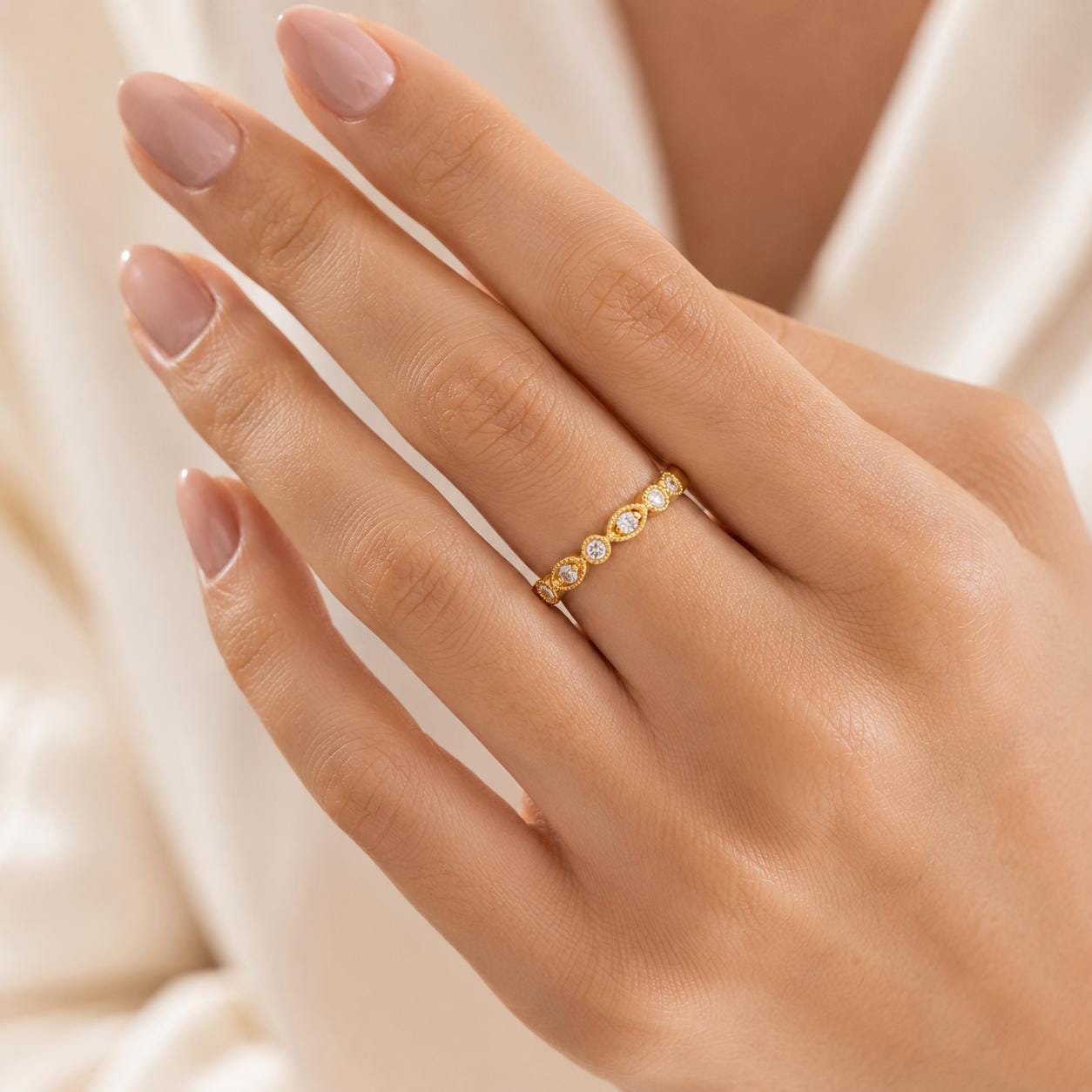 A close-up of a person's hand wearing a gold ring with small diamonds.