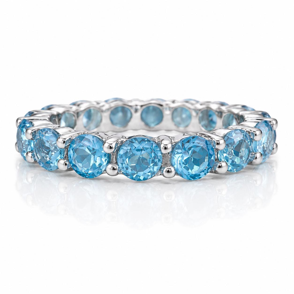 A silver band with a row of blue gemstones, likely diamonds, set in a decorative pattern.