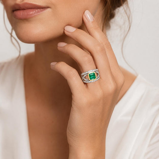 A close-up of a woman's hand wearing a ring with a large green gemstone, resting on her finger.