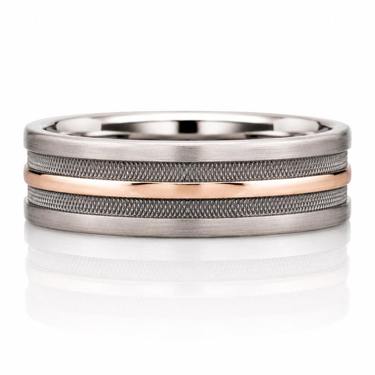 A silver and gold ring with a metallic texture and a thin, horizontal band.