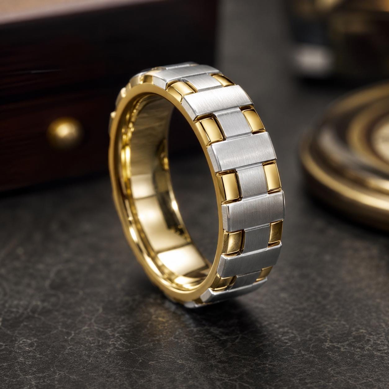 A gold and silver men's ring with a unique geometric design, displayed on a dark surface.