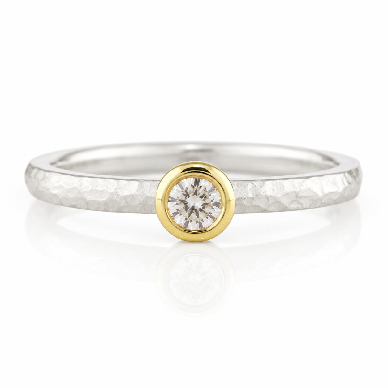 A silver ring with a large diamond set in the center, surrounded by a thin gold band.