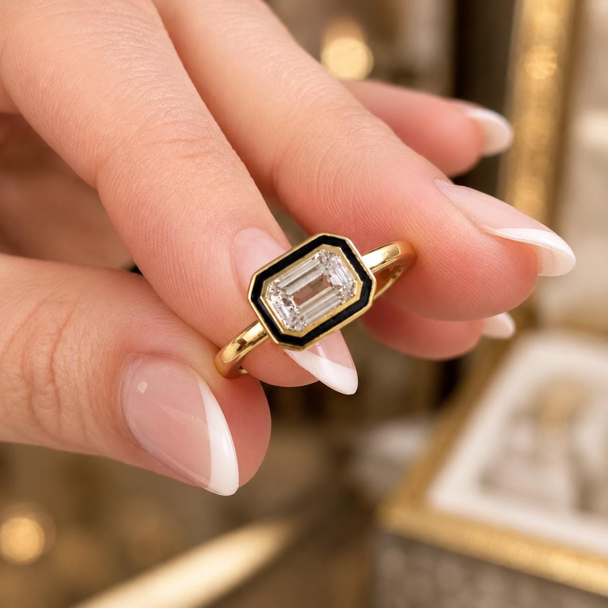A close-up of a person's hand holding a gold ring with a large, clear gemstone in the center.