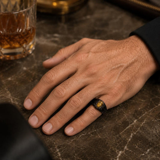 A close-up image of a hand resting on a marble surface, wearing a ring with a yellow gemstone.