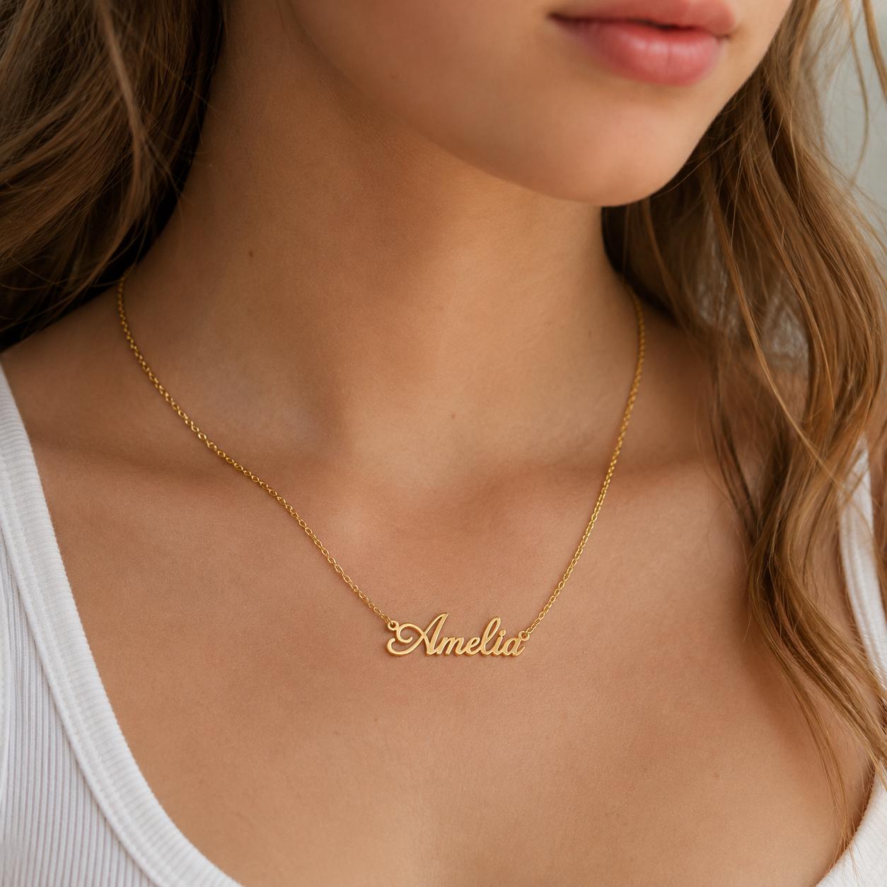A close-up of a woman's neck wearing a gold necklace with the name "Amelia" engraved on it.