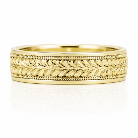 A gold ring with a decorative band featuring a leaf-like pattern.