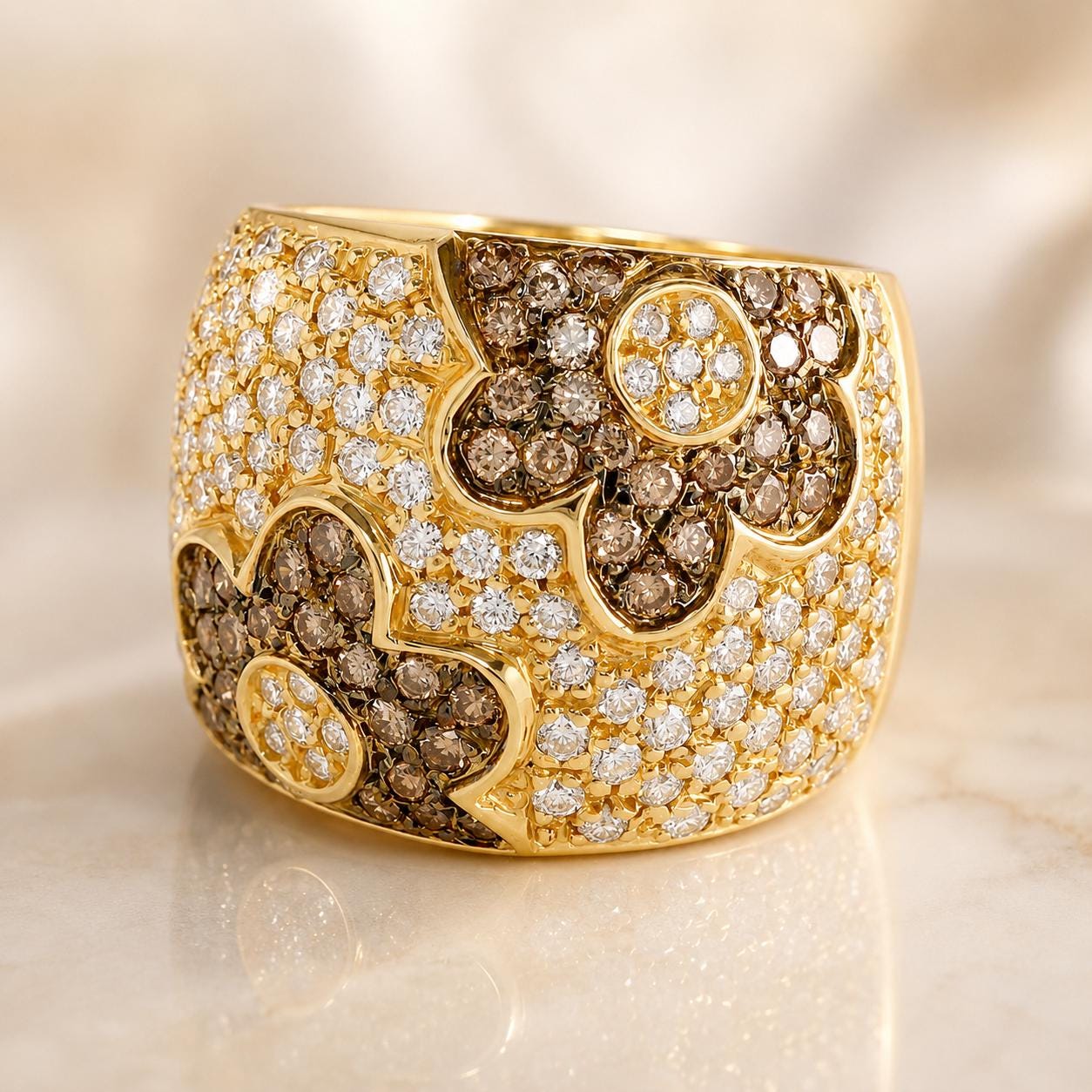 A gold ring adorned with a large, intricate design of diamonds in various shapes and sizes, including a prominent flower-like pattern.