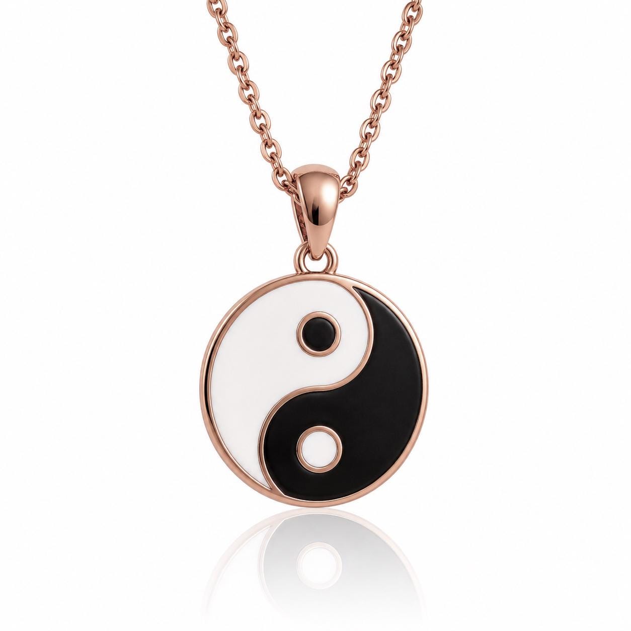 A rose gold necklace with a circular pendant featuring a yin and yang symbol, which is a traditional symbol of balance and harmony.