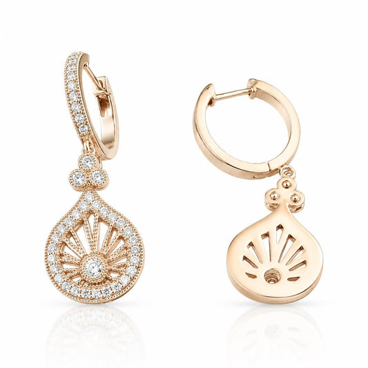two gold earrings with intricate designs and sparkling gemstones.