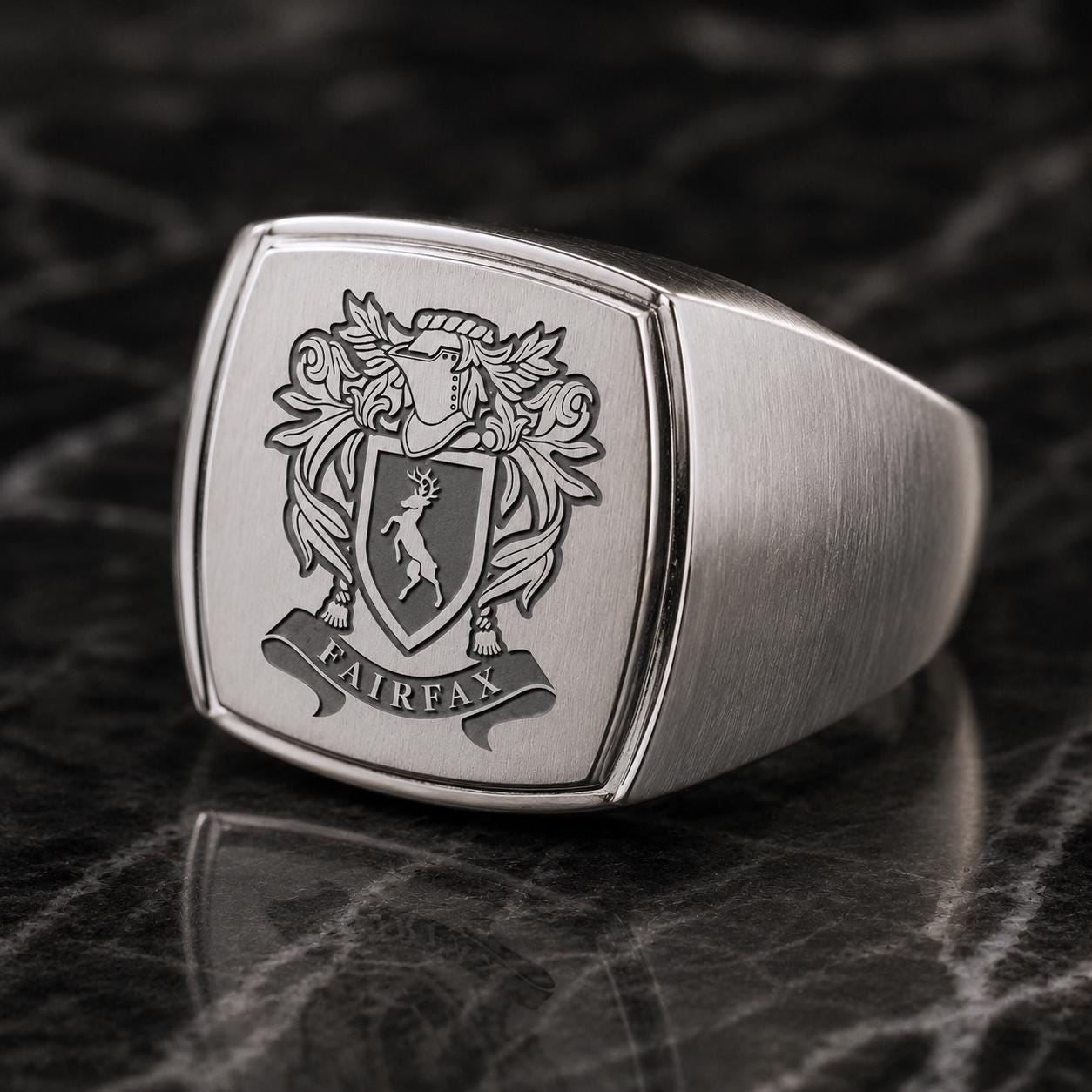 A silver ring with a crest and the word "FAIRFAX" engraved on it.