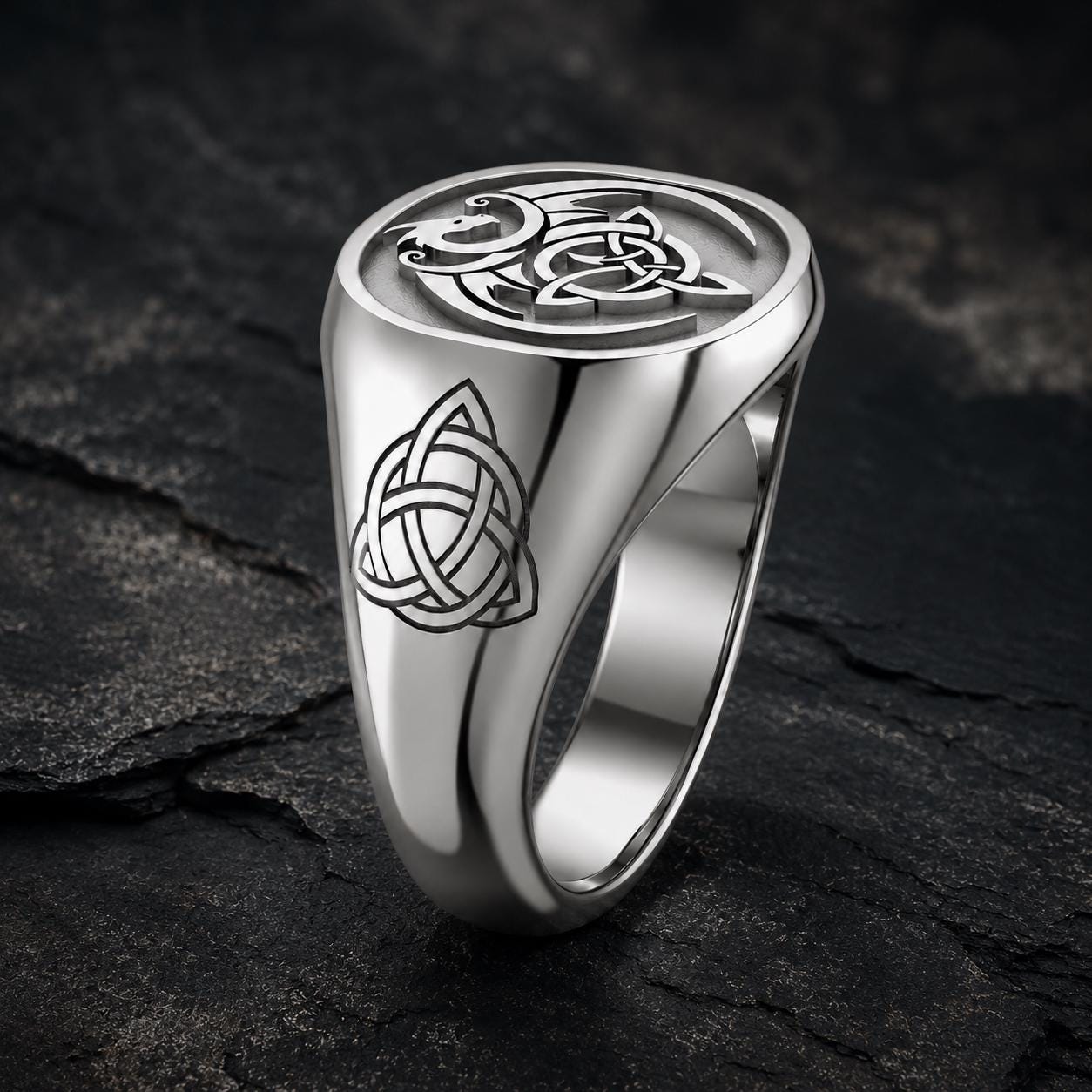 A silver ring with a Celtic knot design on the surface.
